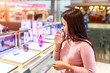 © Southtownboy Studio - Young asian woman testing and choose to buy perfume in duty free store at international airport.