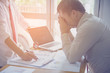 © EKKAPON - business, people, paperwork and deadline concept - stressed businessman with papers and charts sitting at table in office