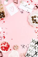 Frame Of Chocolate Candies, Heat Symbols On Pale Pink Background. Flat Lay, Top View Valentine's Day Or Love Concept.