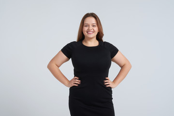 Happy woman in black dress posing at camera