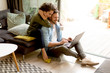 © BGStock72 - Young couple sitting on floor and using notebook.