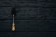 Spoon with black caviar on a wooden background. Top view. Free space for text.