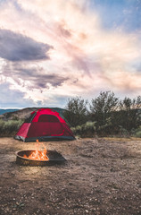 camping with a fire and tent.