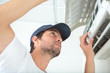 © auremar - young man cleaning air conditioning system