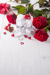 Canvas Print - fresh red roses and gift box on wooden table