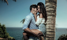 Portrait Of Attractive Lovers Leaning On A Palm Tree