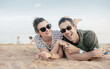 Portrait of a cheerful, relaxed couple laying on sand
