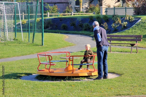 Fotografie, Obraz Un grand-père joue avec son petit-fils dans un square