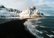 © Michael Schauer - View of black sand beach with snow covered mountain in background