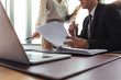 © Jacob Lund - Colleagues comparing documents in office