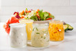 Set of classic salad dressings - honey mustard, ranch, vinaigrette, lemon & olive oil,  on white marble table, copy space