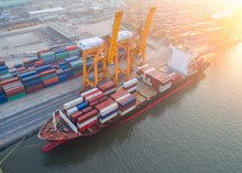 Aerial View Of Containers Yard In Port Congestion With Ship Vessels Are Loading And Discharging Operations Of The Transportation In International Port.Shot From Drone.