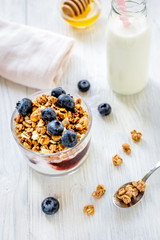 Fitness breakfast with granola, milk and honey on white backgrou