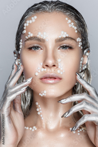 Fotografie, Obraz Beautiful woman portrait with pearl beads on face, silver hair and wet skin and sinver hands