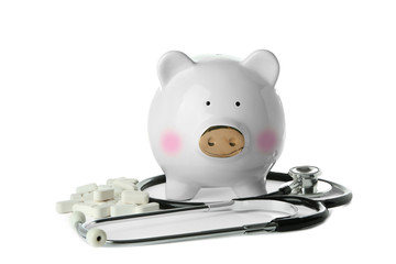 Poster - Piggy bank with stethoscope and pills on white background. Health care concept