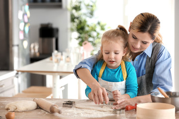 Canvas Print - Mother and daughter with dough at table indoors