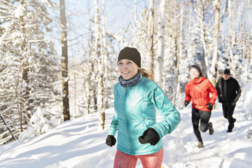 Group of friends enjoying jogging in the snow in winter