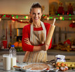 © Alliance - Portrait of smiling young housewife with rolling pin
