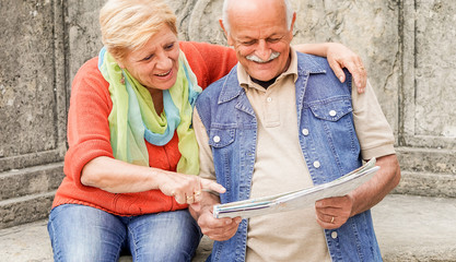 Senior couple reading tourist map inside italian castle outdoor - Mature Husband and wife having fun in romantic vacation- Love and joyful elderly lifestyle concept