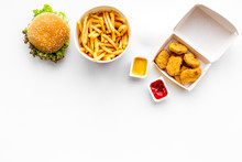 Fast Food. Chiken Nuggets, Burgers And French Fries On White Background Top View Space For Text