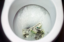 Flush Money Down The Toilet, Throws Dollar Bills In The Toilet, Loss Concept, Close Up, Selective Focus