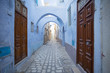 old wooden doors and blue walls on the street in old town in Tunisia