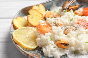 Wall Mural - Plate with tasty seafood risotto on table, closeup