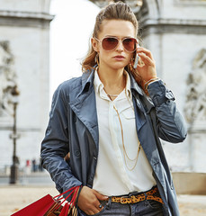 fashion-monger with shopping bags in Paris using mobile phone