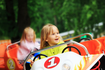 happy little girl on roller coaster ride in amusement park