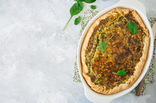 Quiche With Spinach And Cheese - Savory Tart From Flaky Dough On A White Stone Backround With Copy Space.