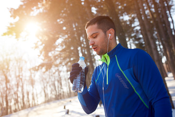 Wall Mural - Thirsty athlete on training in woods