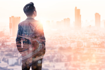 the double exposure image of the business man standing back during sunrise overlay with cityscape im