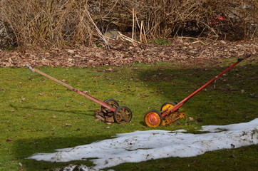 Two very old push reel type mowers left out in the snow