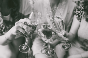 closeup view of three female young hands holding wineglasses with champagne. future bride with her g