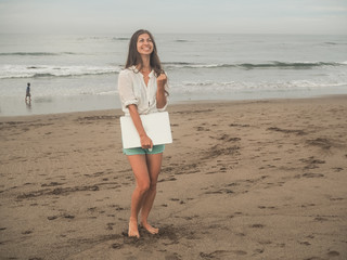 successful Digital Nomad girl with laptop on the beach