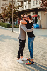 Friends hugging in the street and smiling