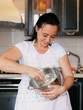 © yolya_ilyasova - Plump woman cooking on the kitchen. Mature woman in pastel apron kneads a dough in a metal bowl and smiling.