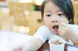 © MIA Studio - Little asian girl boring when she eating chocolate ice cream cup alone.