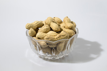 Peanuts in a crystal glass in a white background