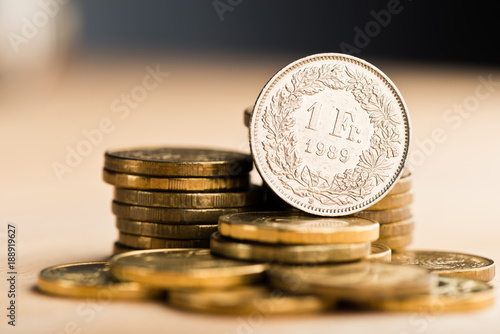 Fotomural one swiss frank coin and gold money on the desk