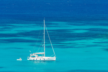 Yacht sitting in crystal clear waters off the coast of Mykonos, Greece, Europe.