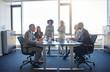 © Flamingo Images - Businesspeople talking around a table in a modern office