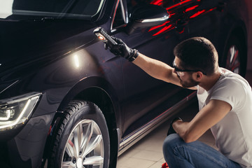 man checks the polishing with a torch