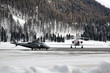 A helicopter and a private jet in the snowy landscape and mountains of the alps switzerland