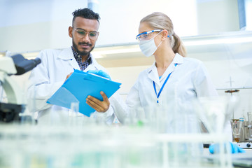 Wall Mural - International team of scientists working together in medical laboratory doing research on  chemicals and bacteria