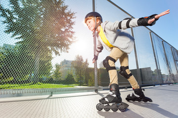 Wall Mural - Active boy in helmet rollerblading at skate park