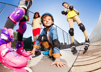 Wall Mural - Cute boy in roller skates having fun with friends