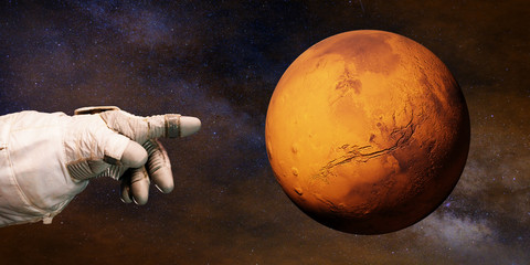 Wall Mural - astronaut pointing to the red planet mars