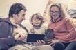 © scaliger - Happy family with baby girl using a digital tablet