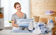 Happy woman housewife ironing clothes   in laundry at home